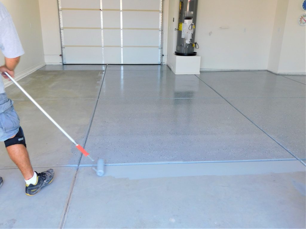 person coating garage floor